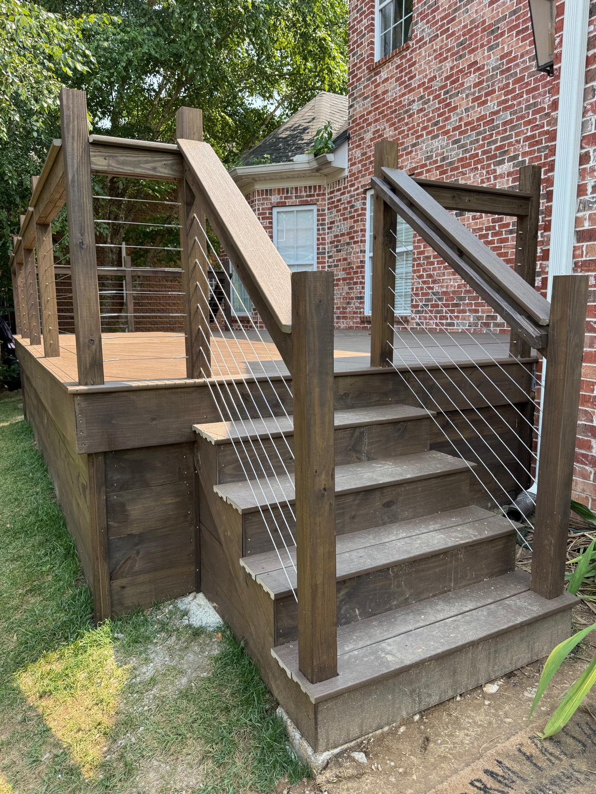 Close view of wood deck stairs and horizontal cable railing