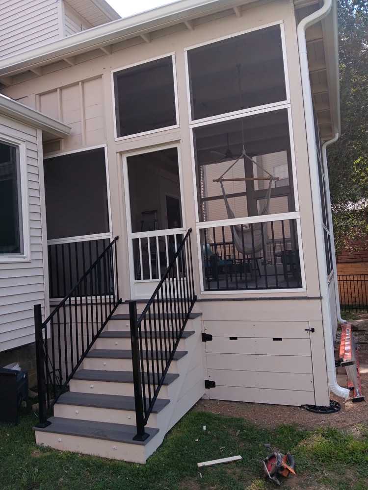 Southpine Design screened porch with a tall roofline, black railing, and illuminated stair treads